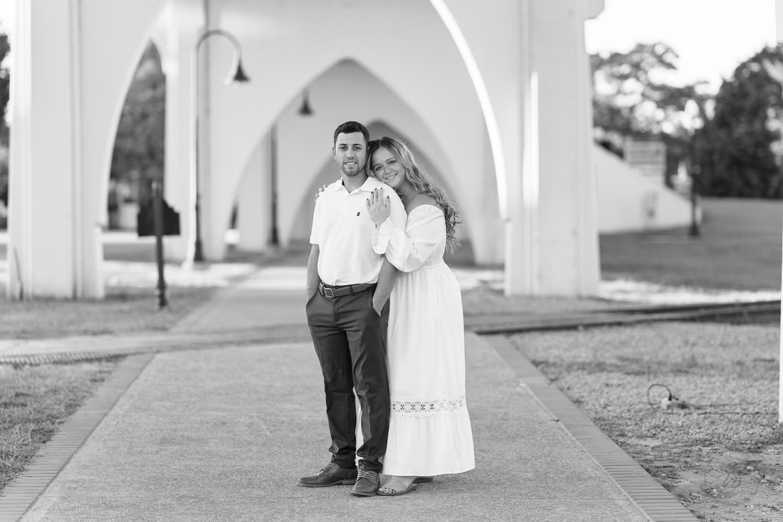 Couple under the white arches in black and white - Conway Riverwalk