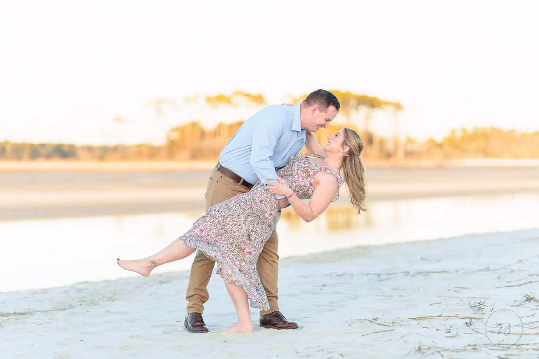 He dips her for a kiss on the sand by the water - Cherry Grove Point