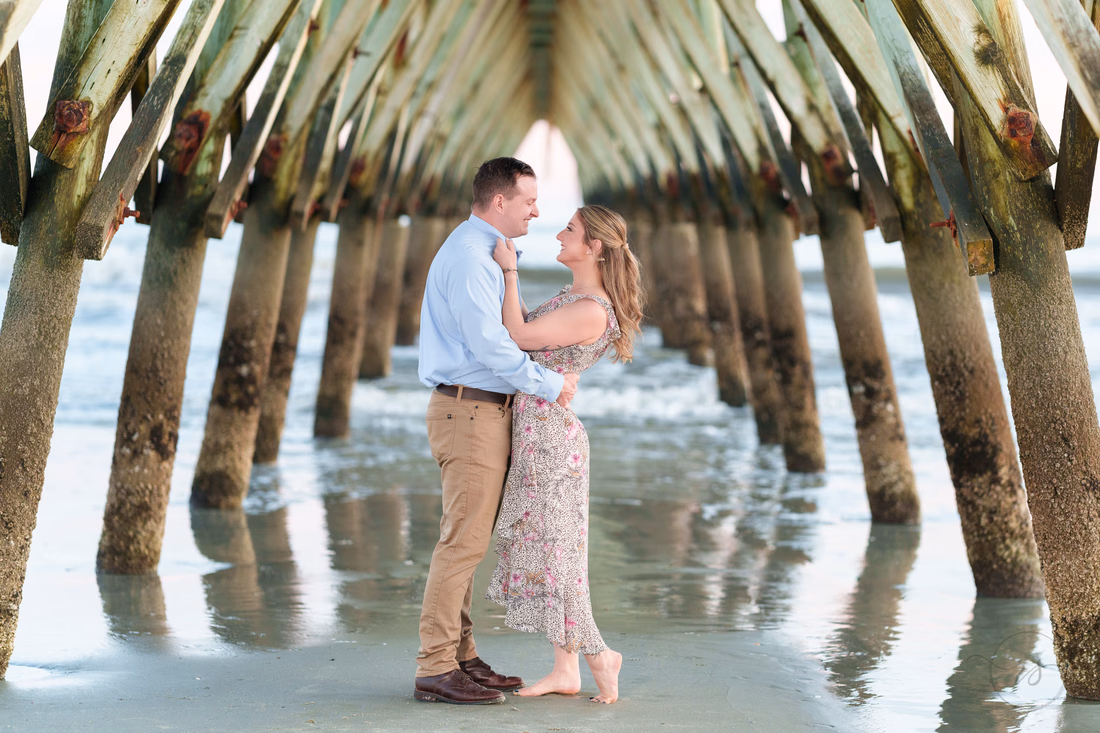 Couple embracing under the pier - Cherry Grove Point