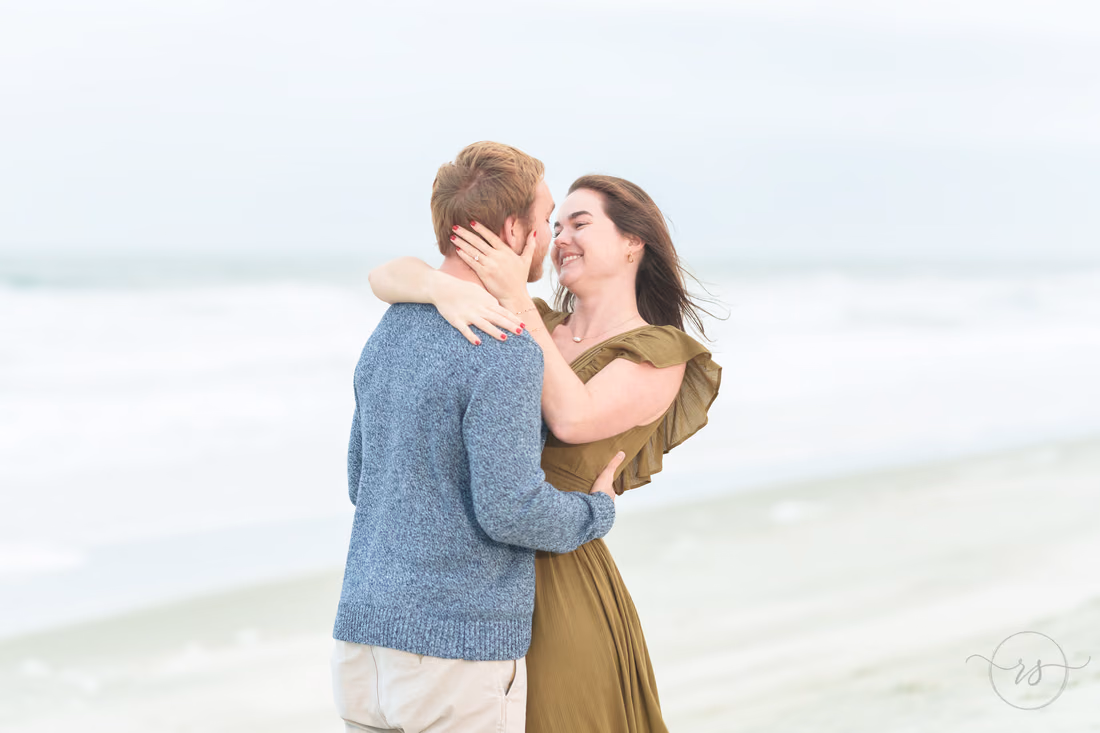 Couple laughing in a hug on a cloudy beach - Huntington Beach State Park