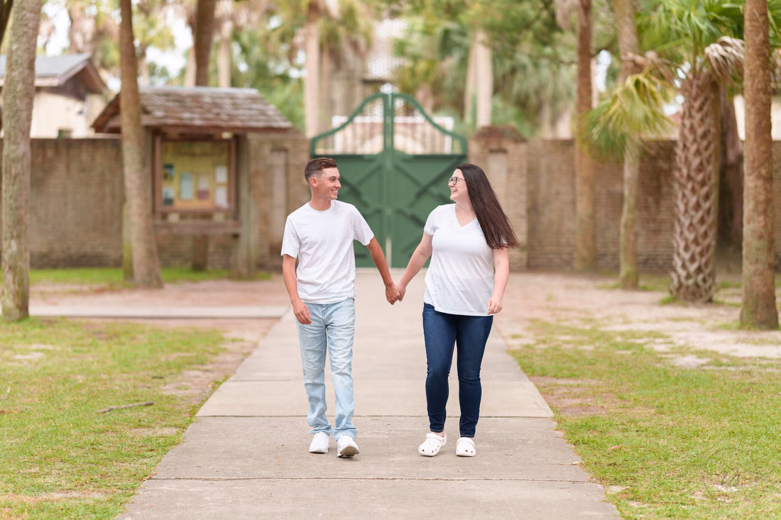 Couple walking hand in hand toward the Atalaya Castle gate - Huntington Beach State Park