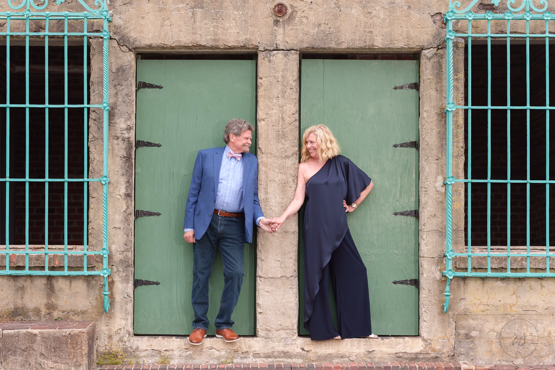 Senior couple holding hands in a green doorway at Atalaya Castle - Huntington Beach State Park