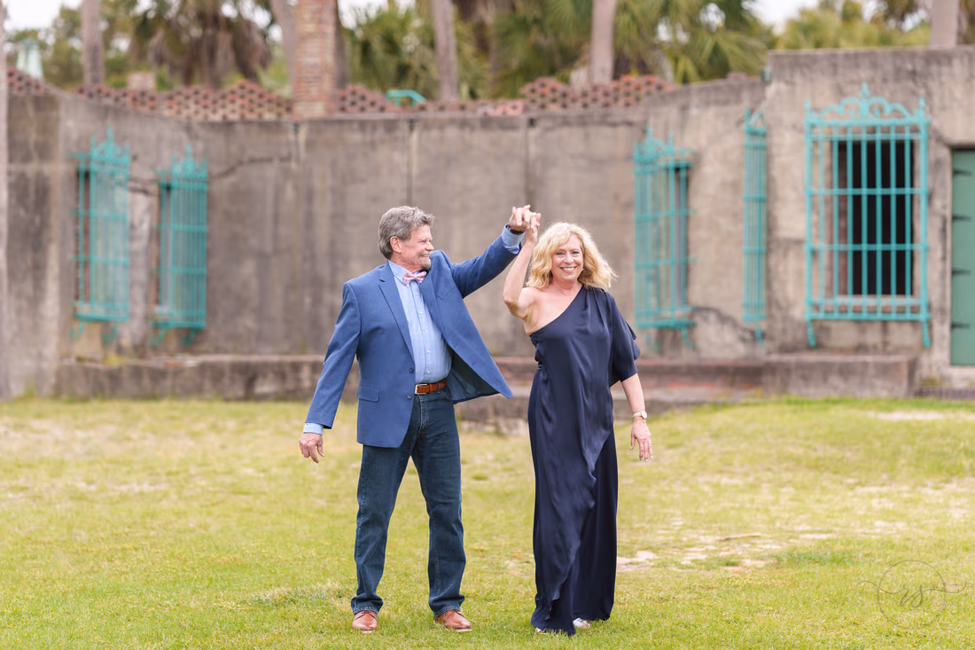 Senior couple dancing on the lawn in front of Atalaya Castle - Huntington Beach State Park