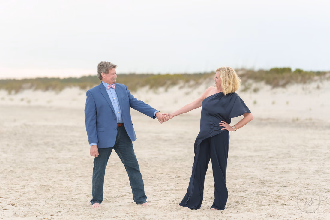 Senior couple playfully holding hands on the beach - Huntington Beach State Park