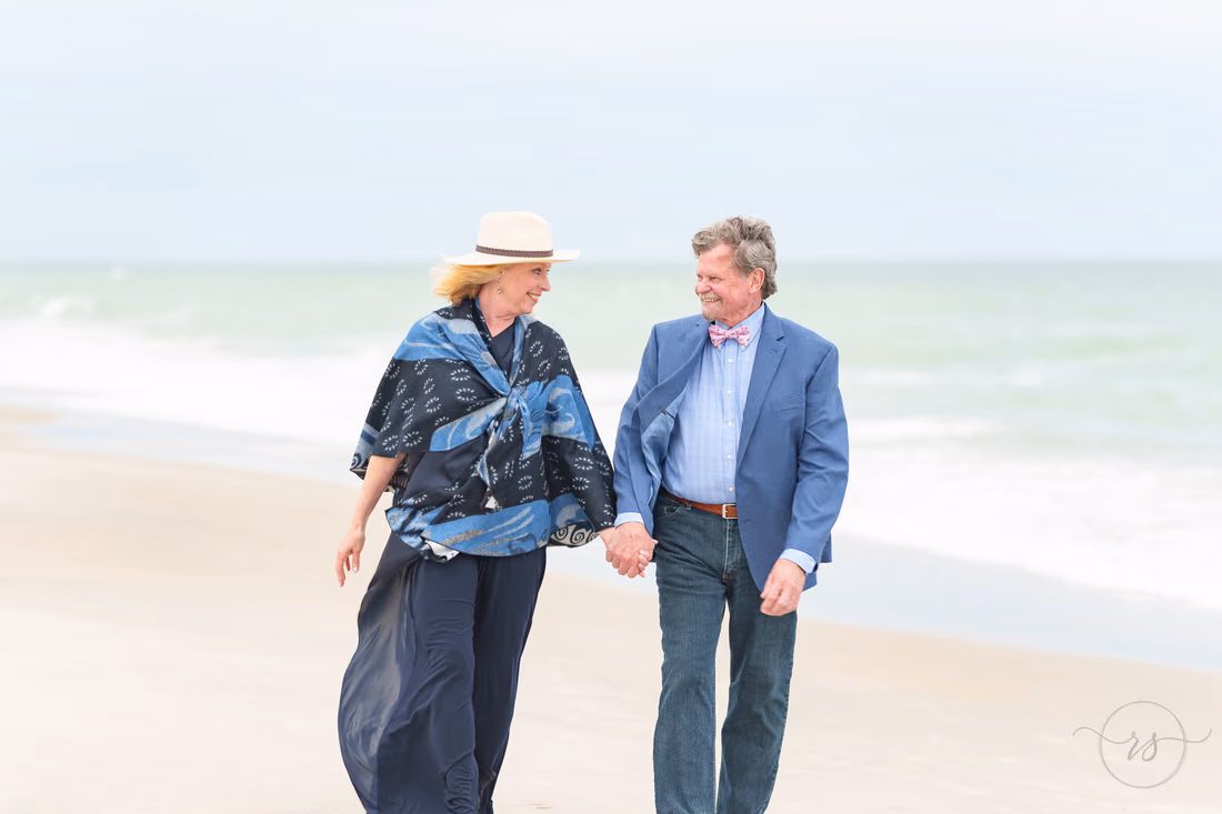 Senior couple walking hand in hand along the shore - Huntington Beach State Park