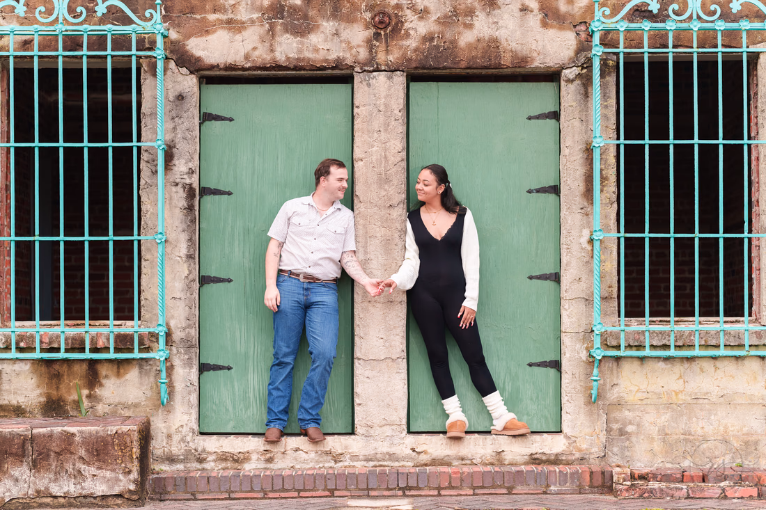 Couple holding hands in the green doorways of Atalaya Castle - Huntington Beach State Park