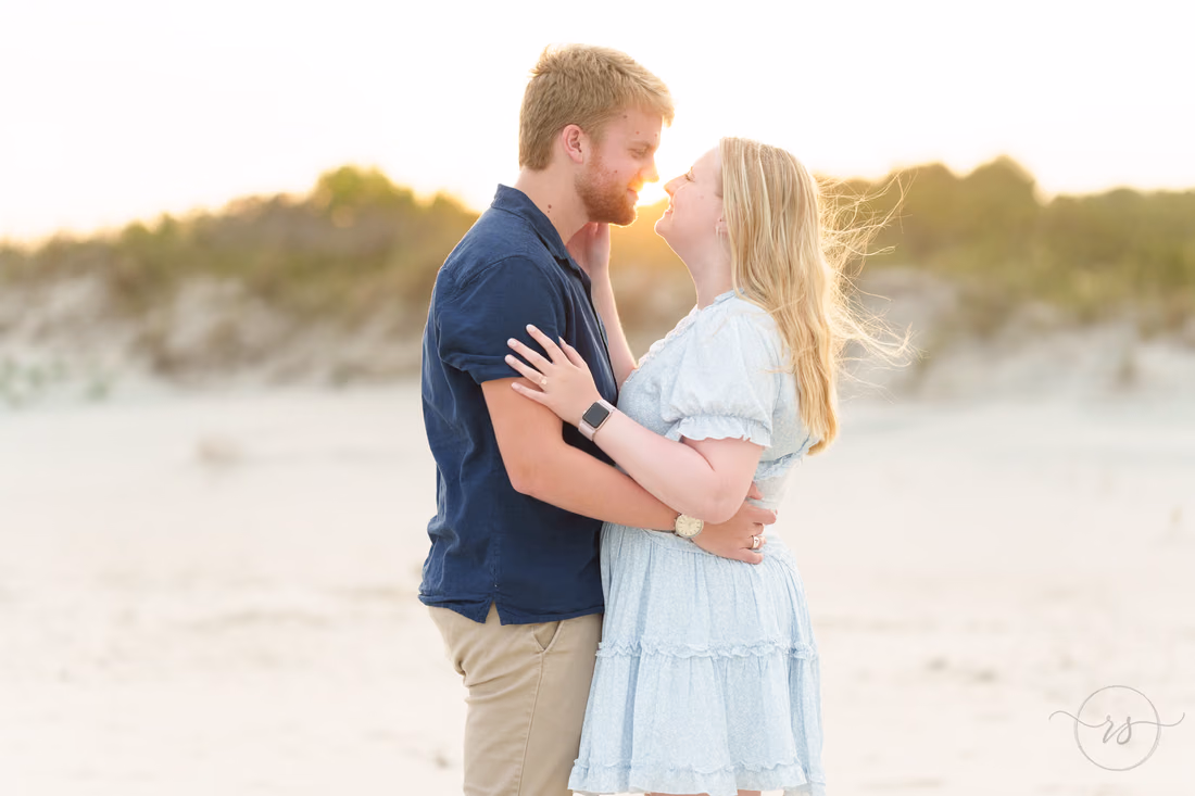 Couple nose to nose by the dunes in the setting sun - Huntington Beach State Park
