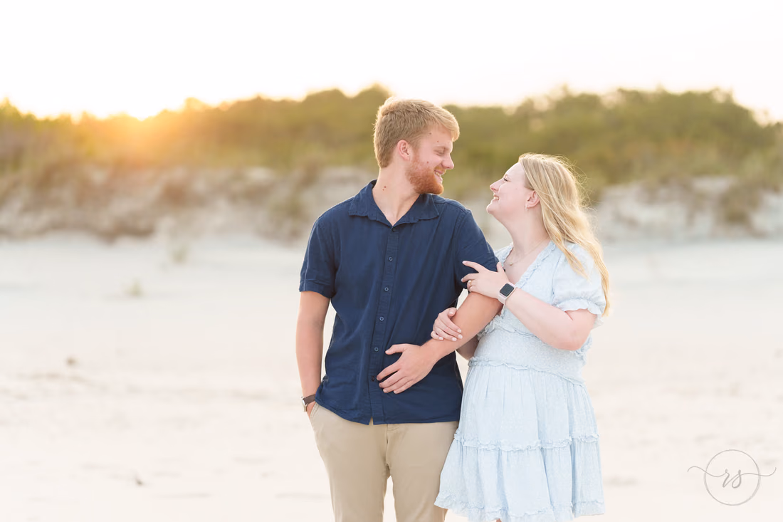 Couple laughing on the sand by the dunes - Huntington Beach State Park