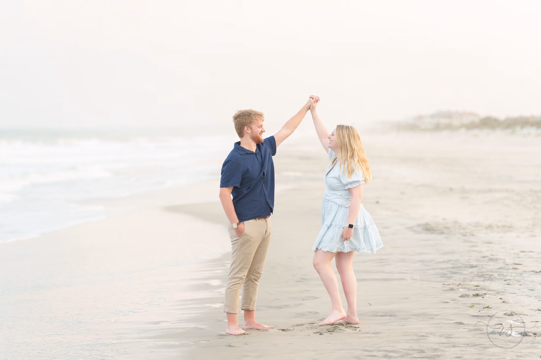 He twirls her at the water's edge - Huntington Beach State Park