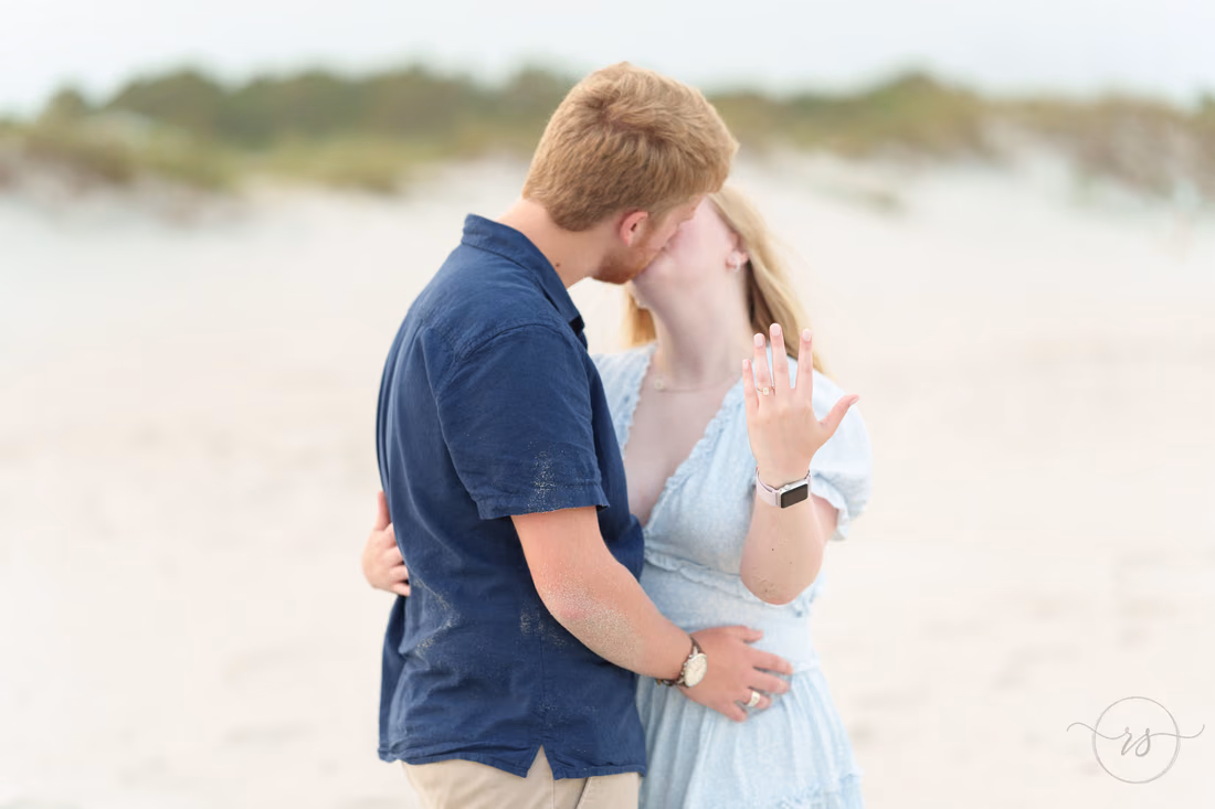 Couple kissing as she shows off her ring by the dunes - Huntington Beach State Park