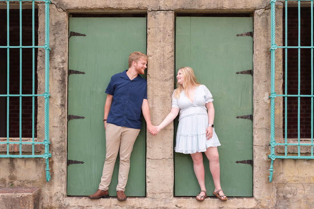 Couple holding hands at the green doors of Atalaya Castle - Huntington Beach State Park