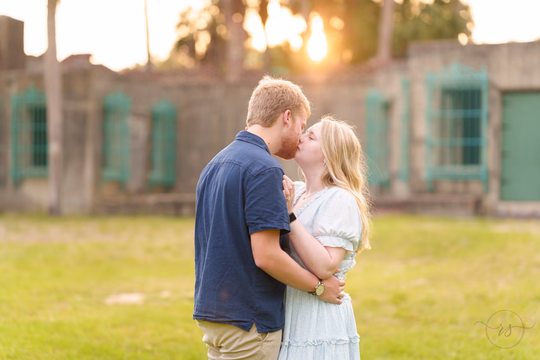 Couple kissing on the lawn at sunset in front of Atalaya Castle - Huntington Beach State Park