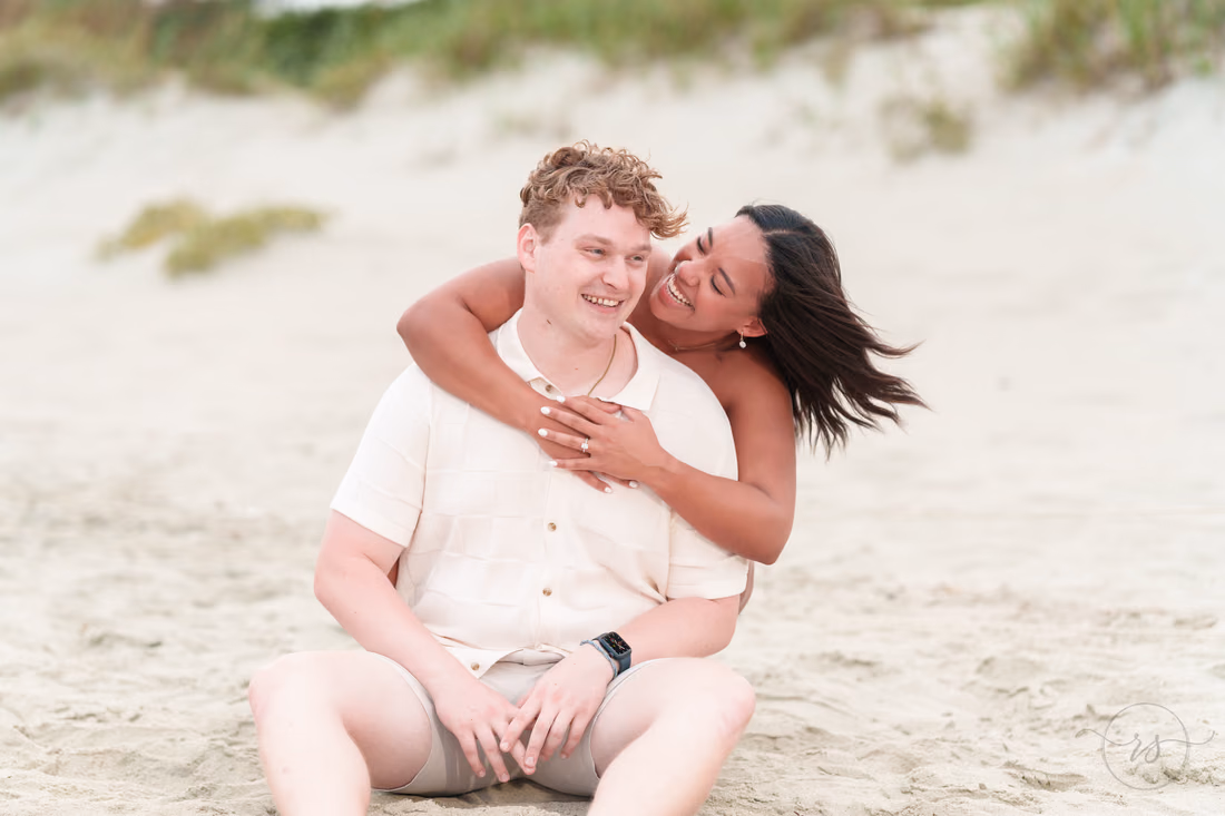 She hugs him from behind in the sand - Myrtle Beach