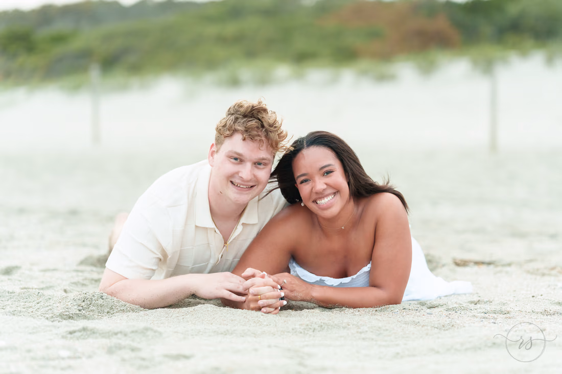 Newly engaged couple lying in the sand smiling - Myrtle Beach