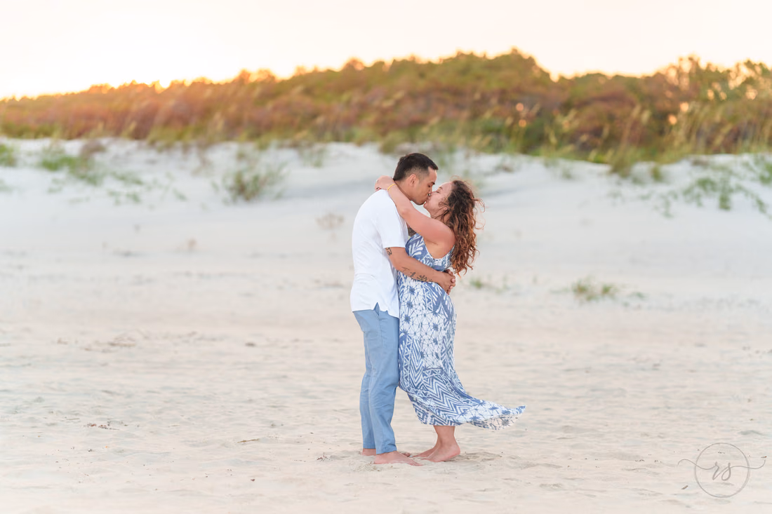 Couple kissing in front of the dunes at sunset - Huntington Beach State Park
