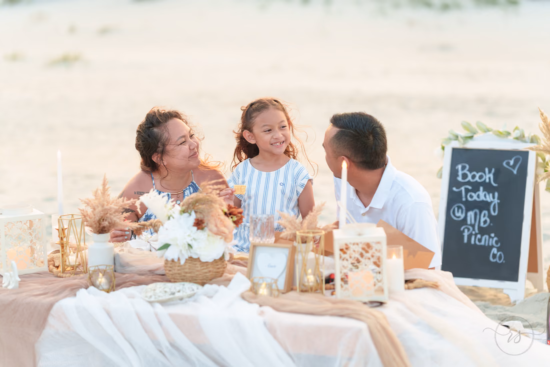 Family laughing together at the MB Picnic Co. table - Huntington Beach State Park