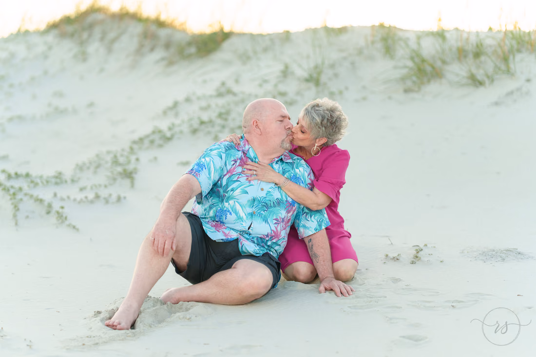 Older couple kissing in the dunes - Huntington Beach State Park