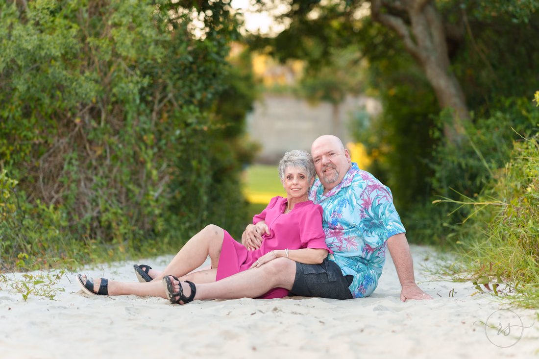 Older couple sitting together on the sandy path - Huntington Beach State Park