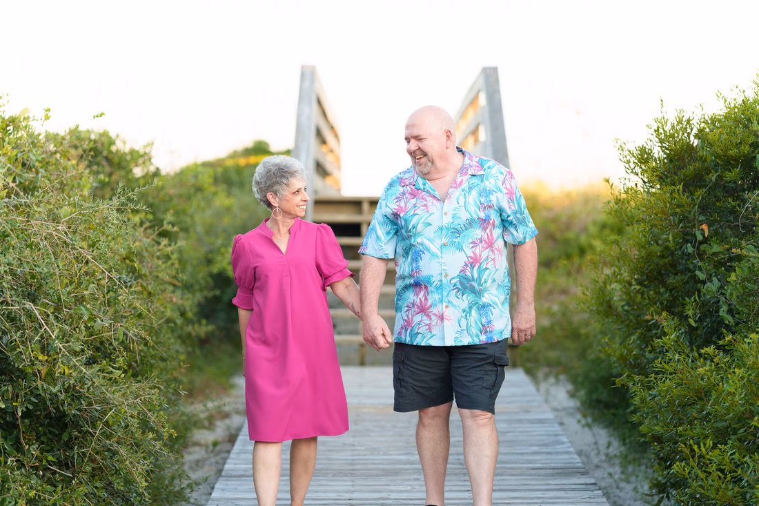 Older couple walking off the beach boardwalk - Huntington Beach State Park