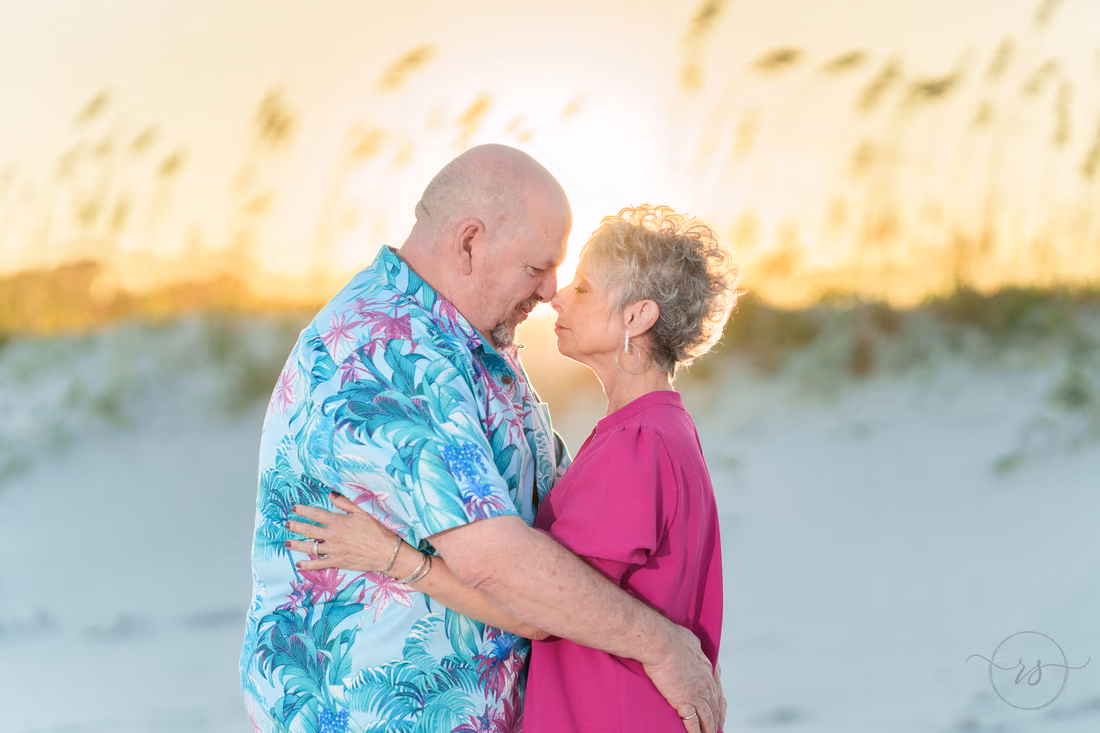 Older couple nose to nose by the sea oats at sunset - Huntington Beach State Park