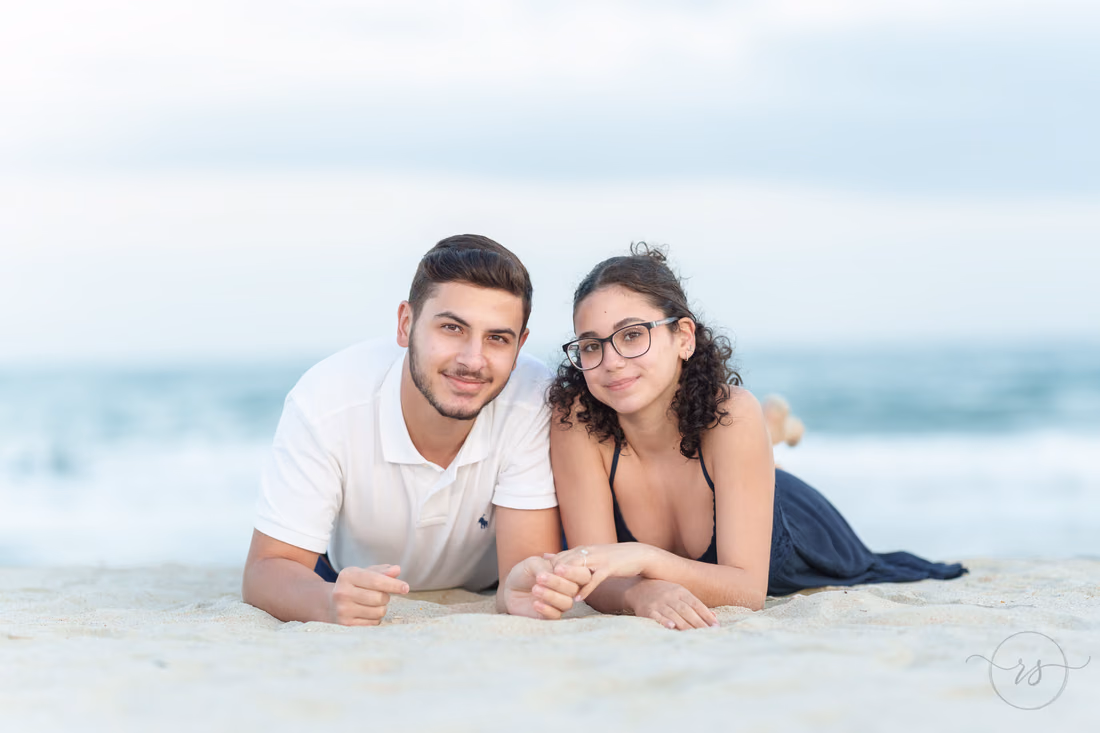 Young couple lying in the sand smiling - Huntington Beach State Park