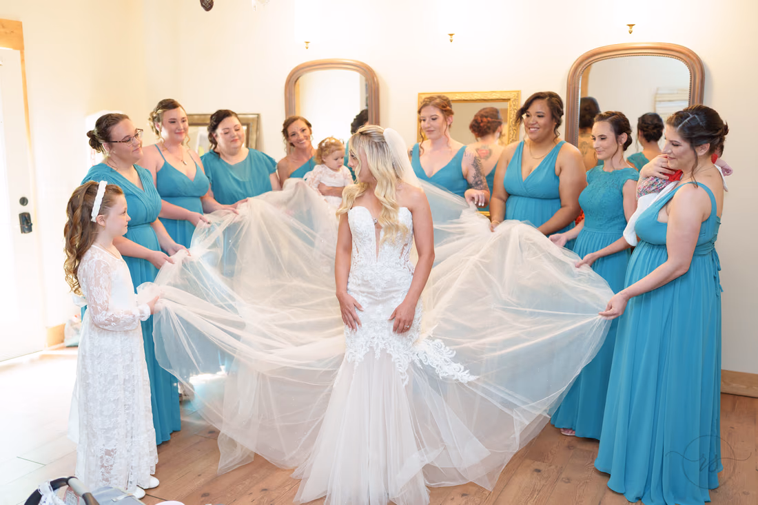 Bridesmaids spreading the bride's tulle skirt out wide in the bridal cottage at Wildhorse at Parker Farms
