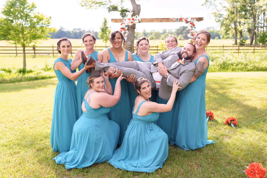 Bridesmaids lifting the groom sideways in their arms at Wildhorse at Parker Farms