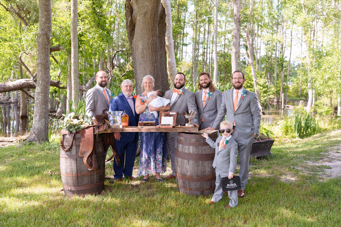 Groom, groomsmen and family gathered at the cigar bar between whiskey barrels at Wildhorse at Parker Farms