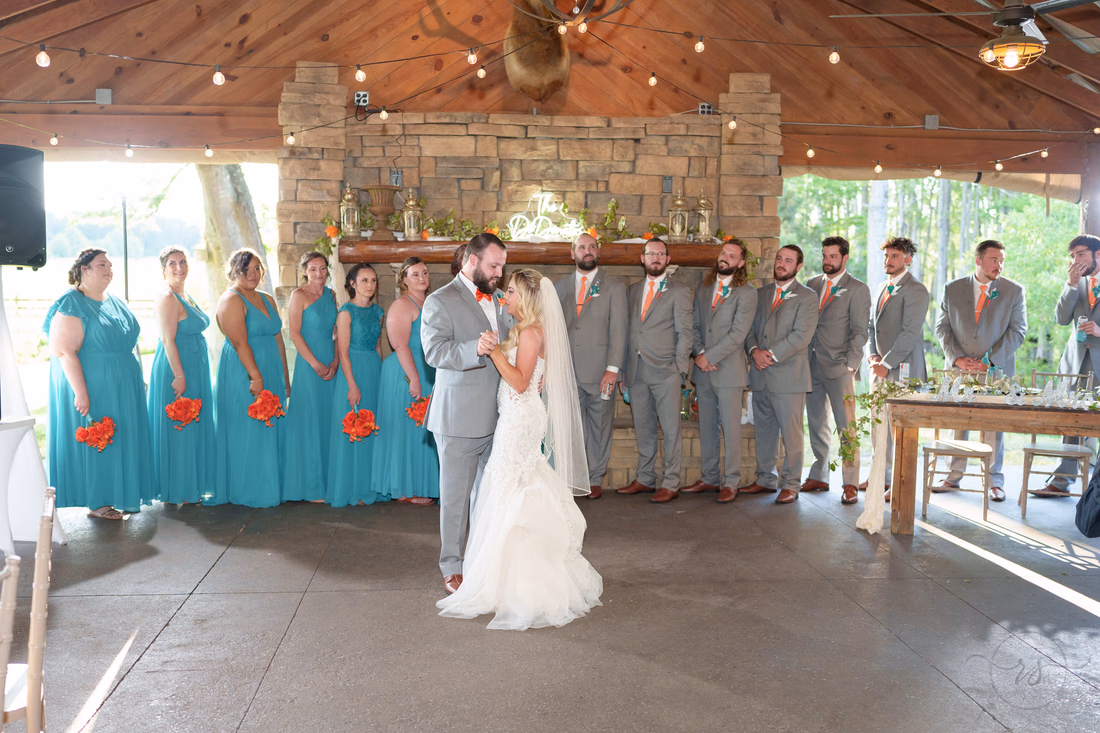 Wide view of the first dance in the open pavilion by the stone fireplace at Wildhorse at Parker Farms