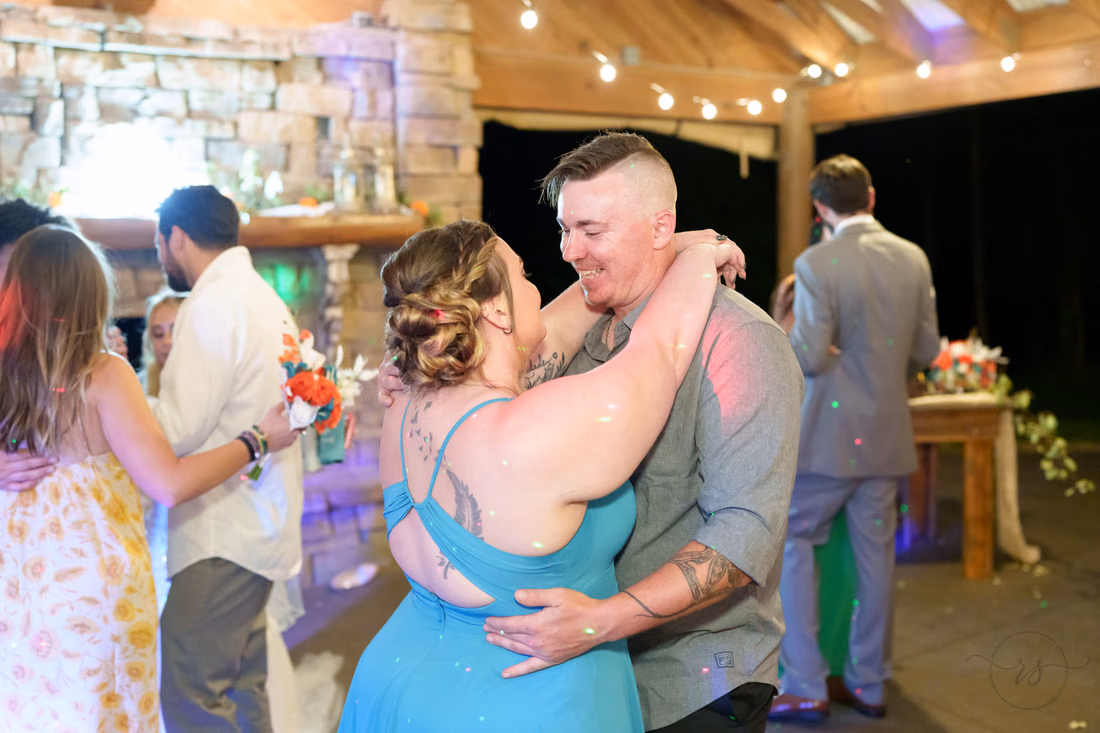 Bridesmaid and a guest dancing and laughing together at Wildhorse at Parker Farms