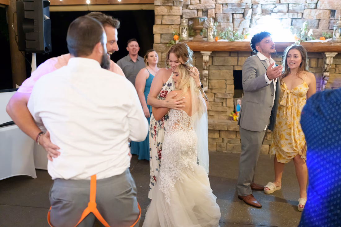 Bride dancing with friends as the groom dances nearby at Wildhorse at Parker Farms