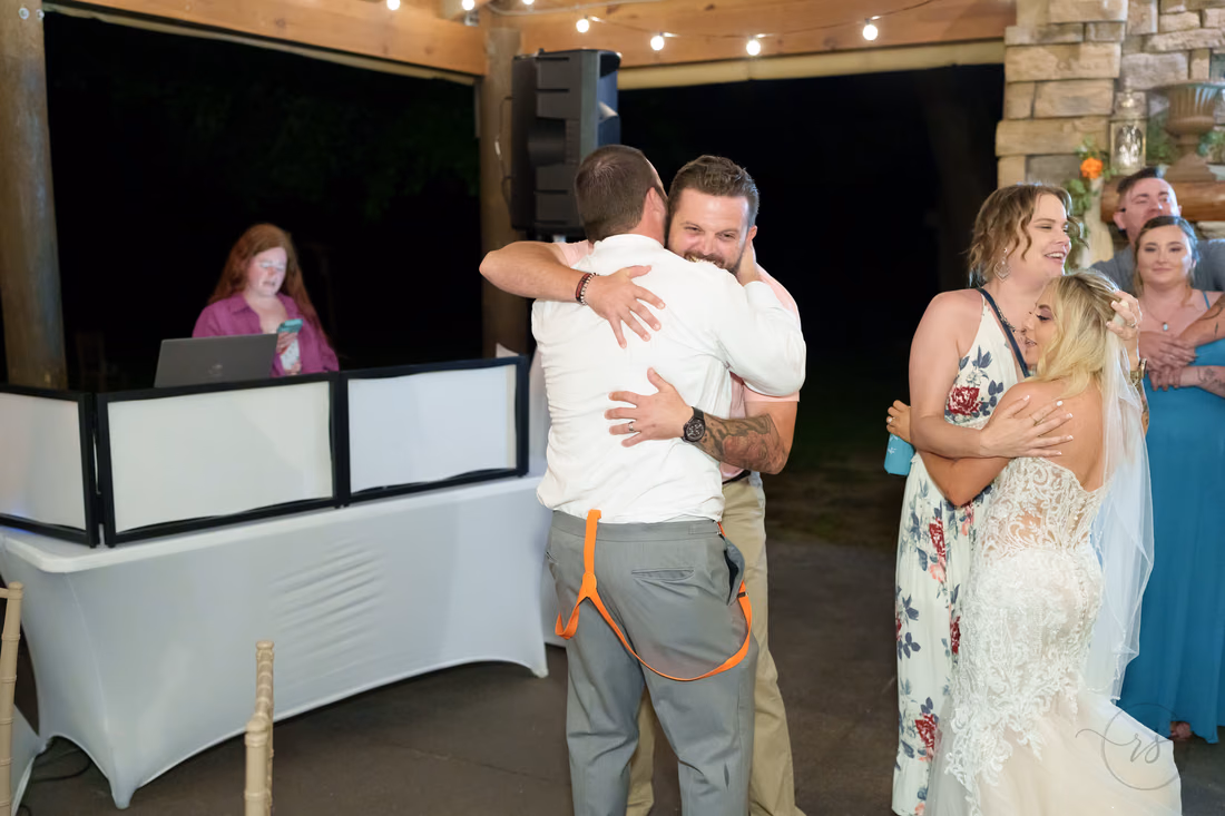 Groom hugging a friend on the dance floor at Wildhorse at Parker Farms