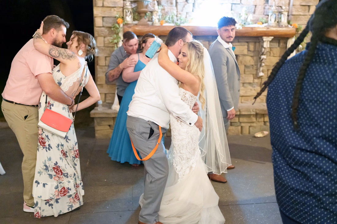 Bride and groom slow dancing among guests by the fireplace at Wildhorse at Parker Farms
