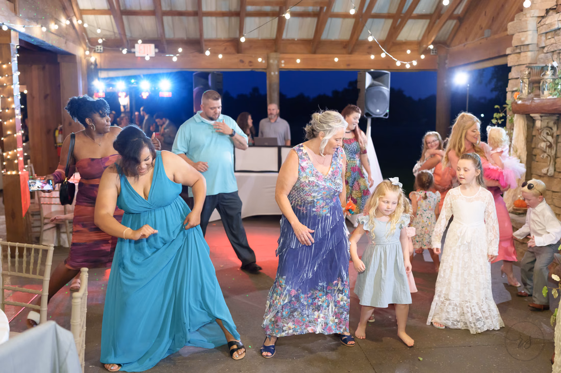 Guests and flower girls dancing under the pavilion lights at Wildhorse at Parker Farms