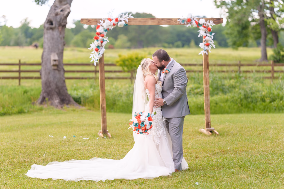 Kiss under the wedding arch - Wildhorse at Parker Farms