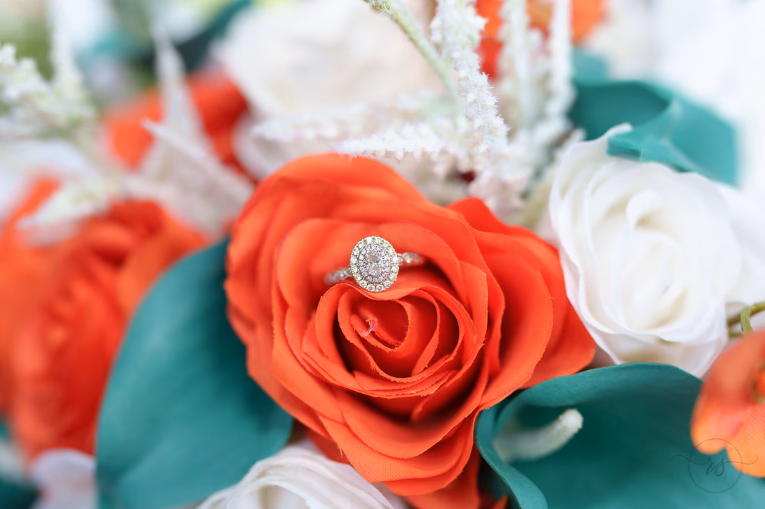 Engagement ring resting in an orange rose in the bouquet at Wildhorse at Parker Farms