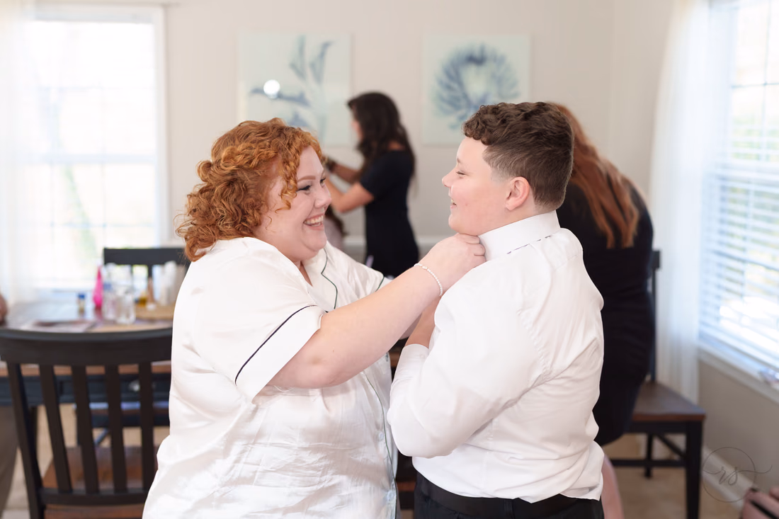 Bride helps her nephew with his collar while getting ready at The Cypress Inn in Conway