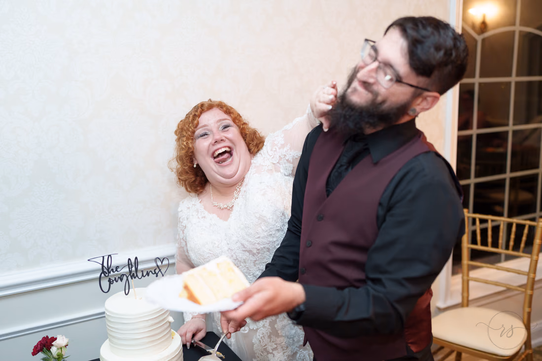 Bride laughs as she smears cake on the groom's face at The Cypress Inn in Conway