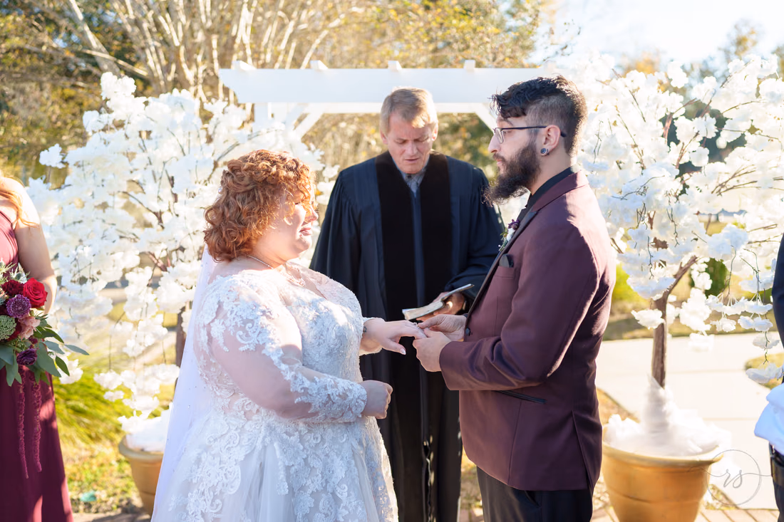 Bride and groom holding hands during the vows under the tent at The Cypress Inn in Conway