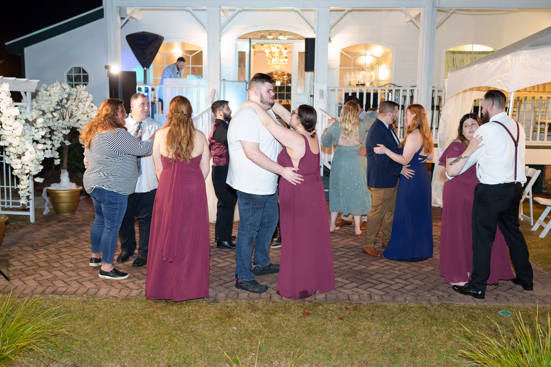 Guests slow dancing on the brick patio in front of the inn at The Cypress Inn in Conway