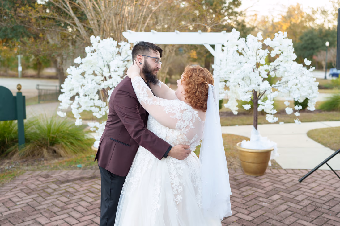 Couple slow dances in front of the white floral trees on the patio at The Cypress Inn in Conway
