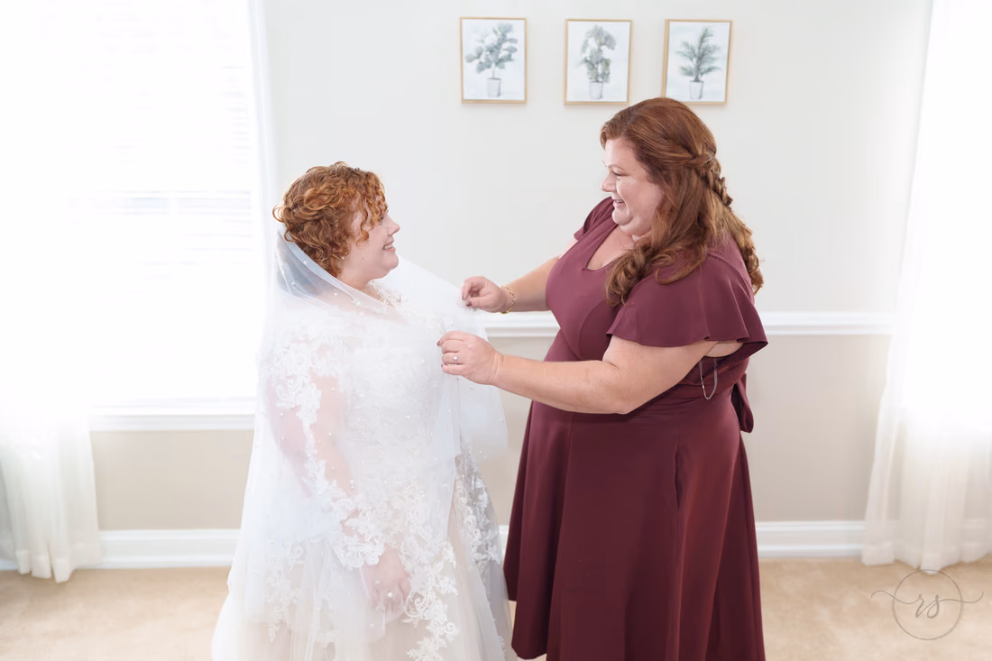 Mom adjusts the veil as the bride laughs by the window at The Cypress Inn in Conway