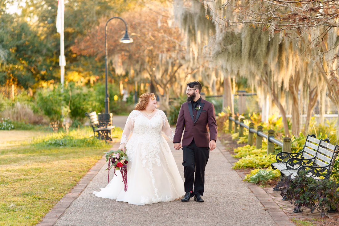 Bride and groom walking hand in hand on the moss-covered path on the Conway Riverwalk