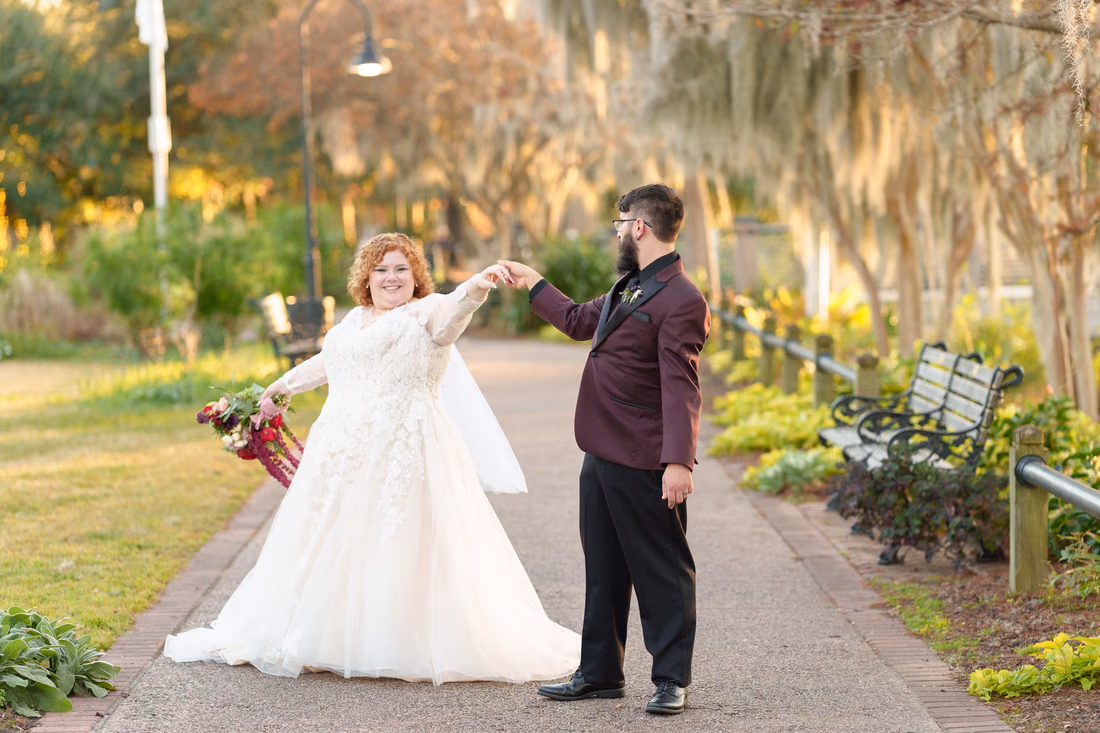 Groom twirls the bride on the moss-covered path on the Conway Riverwalk