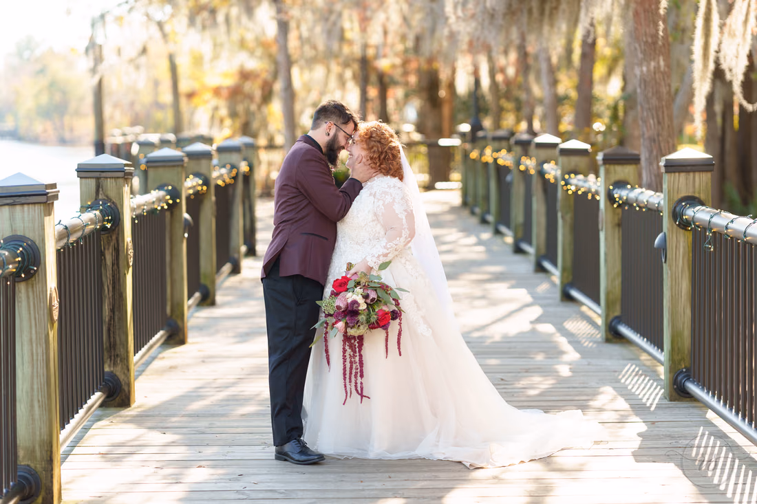 Groom leans his forehead to the bride's on the boardwalk on the Conway Riverwalk