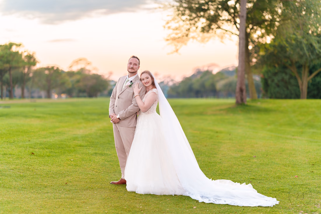 The bride leans on the groom's shoulder on the fairway at Pine Lakes Country Club