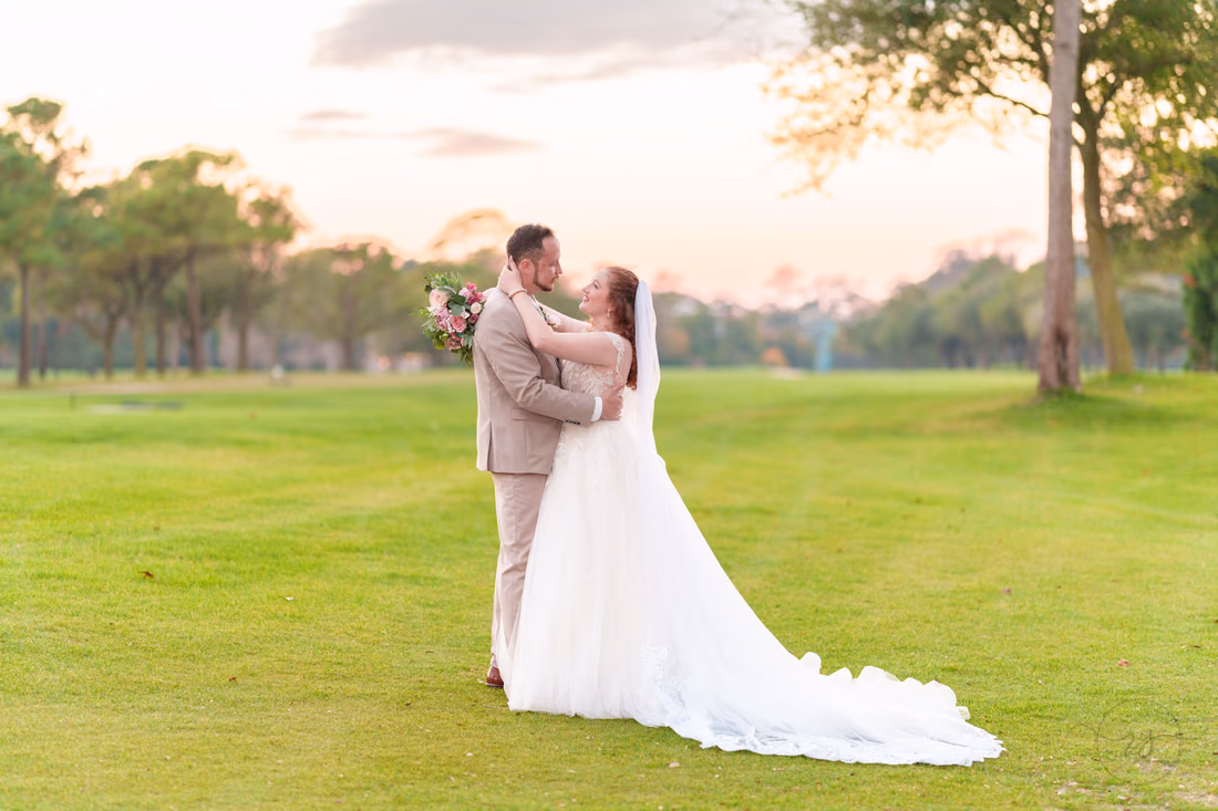 The bride and groom embrace on the golf course after sunset at Pine Lakes Country Club