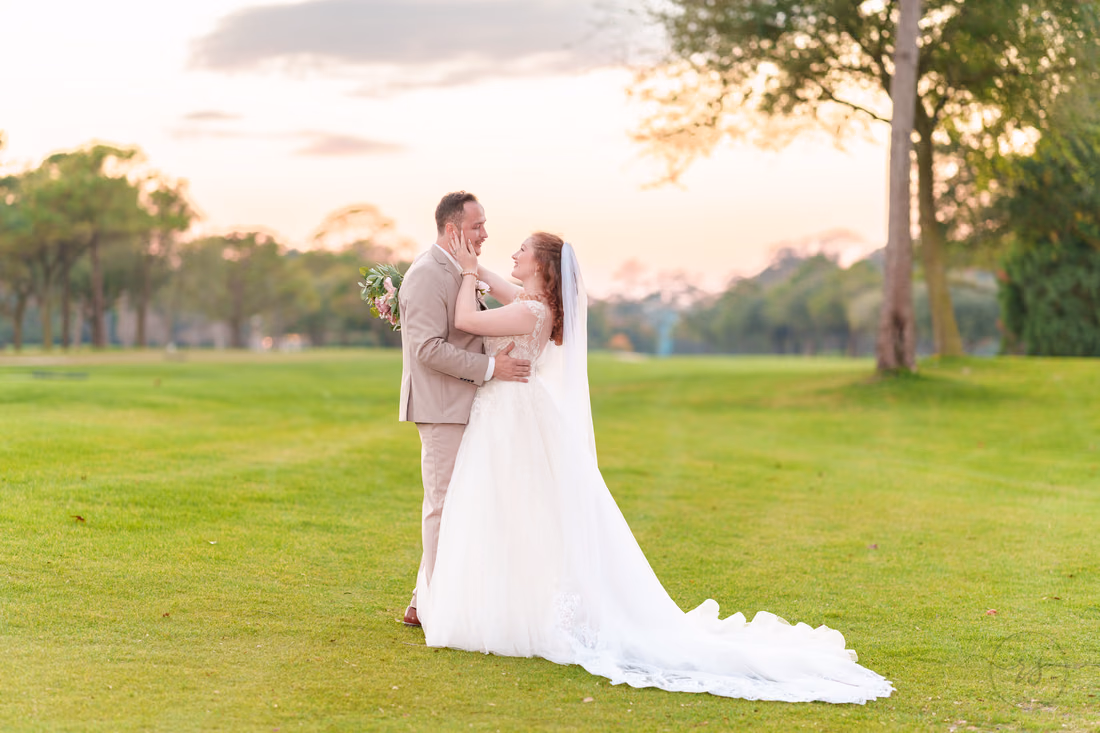 The bride touches the groom's face on the golf course after sunset at Pine Lakes Country Club