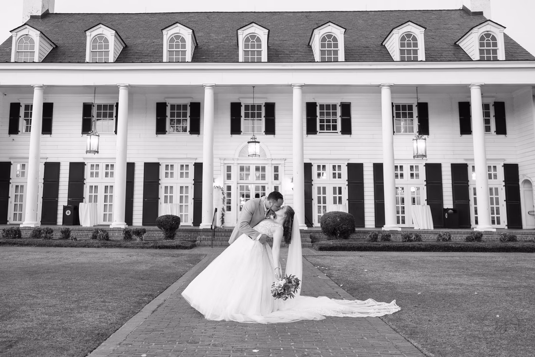 Black and white kiss in front of the clubhouse columns at Pine Lakes Country Club