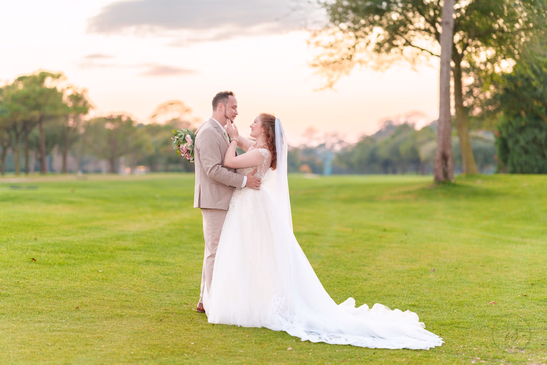 The bride and groom hold each other close on the golf course at dusk at Pine Lakes Country Club